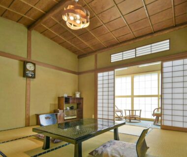 Traditional tatami room with low table, zabuton cushions, shoji screens and window seating at Irorinoyado Ashina in Fukushima