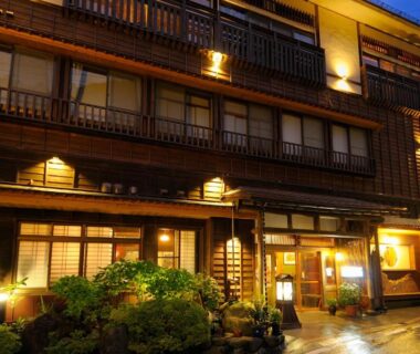 Lit wooden facade and entrance of Irorinoyado Ashina in Fukushima, Tohoku, Japan with small garden