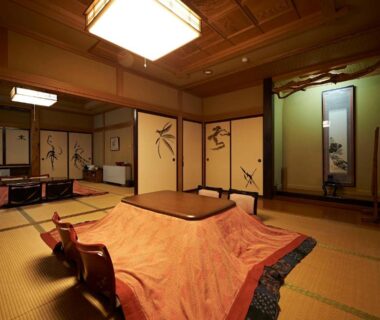 Spacious tatami room with kotatsu, fusuma screens and tokonoma at Irorinoyado Ashina, Fukushima