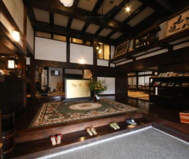 Traditional wooden lobby with rug, slippers, and reception desk at Iroriyado Hidaya in Gifu Chubu