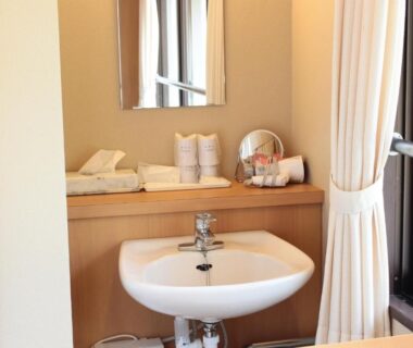 Sink and mirror with towels at Iruka Onsen Hotel Seiryuusou in Mie, Kansai