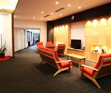 Spacious lounge with wooden seating and low tables at Iruka Onsen Hotel Seiryuusou in Mie, Kansai