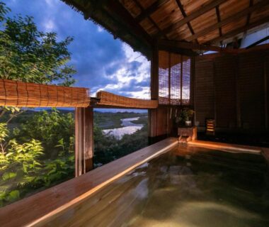 Wooden soaking tub overlooking river and greenery, sheltered room at Isamikan in Tochigi