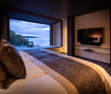 Modern double bed room with large window overlooking coastal waters at Isaribi, Shizuoka, Chūbu Japan