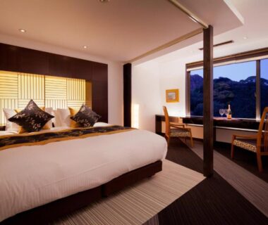 Large bed room with shoji screen, wooden desk and window seating at Isaribi (No Children), Shizuoka