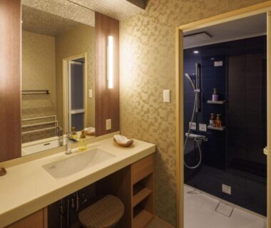 Washbasin vanity and adjoining shower area in ryokan bathroom at Isaribinoyado Seaside Kancho Wakayama