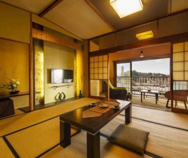 Tatami room with low table, shoji screens and balcony at Isaribinoyado Seaside Kancho in Wakayama