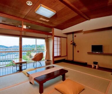 Spacious tatami room with low table, shoji screens and balcony overlooking the sea in Wakayama