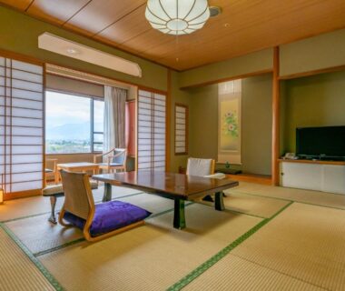 Spacious tatami guest room with low table, cushions, shoji screens and balcony at Isawa Tokiwa Hotel in Yamanashi