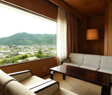 Interior seating area with sofas and large window overlooking town and hills at Isawa Tokiwa Hotel, Yamanashi