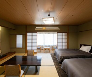 Tatami room with low table, shoji screens and twin beds at Isawa Tokiwa Hotel in Yamanashi, Chūbu