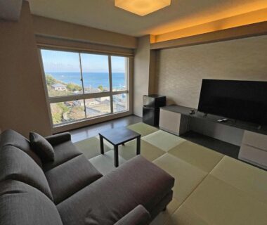 Tatami seating area with sofa, TV and window at Ise-Shima Ohtaya Healing Stay Mie