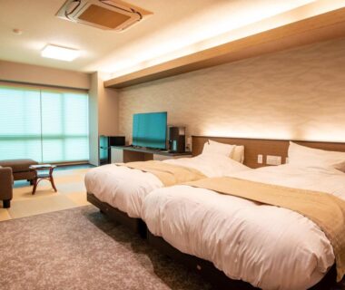 Spacious twin room with seating area and TV at Ise-Shima Ohtaya in Mie