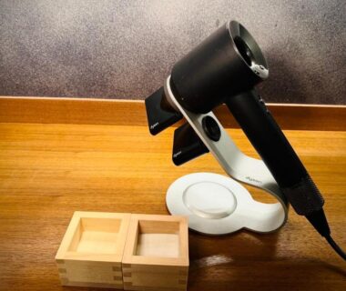 Electric hairdryer on stand beside two wooden masu cups at Ishibekoji Muan ryokan interior, Kyoto