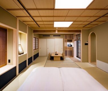 Traditional tatami room with futon, low table and shoji screens at Ishibekoji Muan in Kyoto