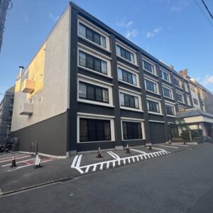 Multi-story building entrance with street parking cones at Ishicho in Kyoto, Kansai