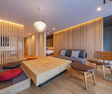Low wooden table with floor cushions and sofa in a room at Ishinoya Atami, Shizuoka, Japan