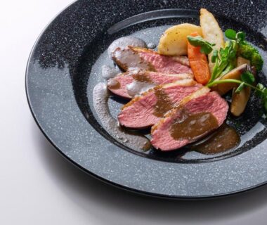 Sliced beef with vegetables on dark ceramic plate at Ishinoyu Lodge in Nagano, Chūbu, Japan