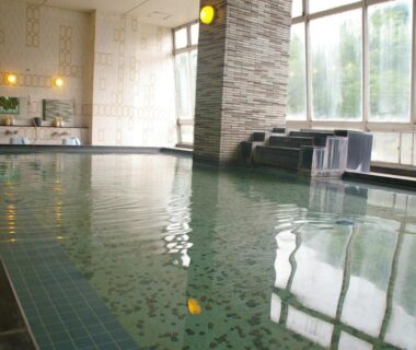 Indoor onsen bath at Itaniya, Nara Kansai with tiled floor, large windows and gentle water spout