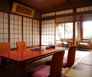 Traditional tatami room with low lacquered table, shoji screens and seating area overlooking garden at Itaniya in Nara