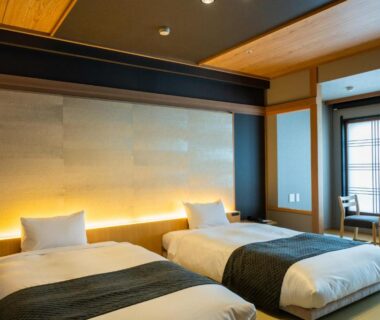 Twin beds on tatami floor with shoji screens and window seating at Ito Kowakien in Shizuoka