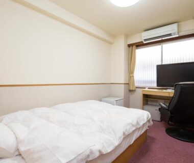 Double bed with duvet, desk, TV and air conditioner at Itoen Hotel Asamanoyu Nagano