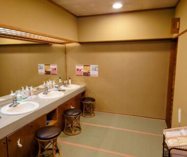 Shared washbasin area with sinks and stools at Itoen Hotel Asamanoyu, Nagano
