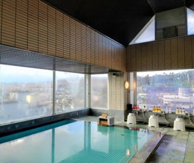 Indoor onsen bath with stools and washing stations at Itoen Hotel Asamanoyu Nagano