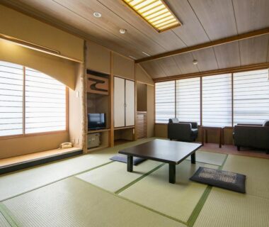 Tatami room with low table, zabuton cushions and shoji screens at Itoen Hotel Asamanoyu in Nagano