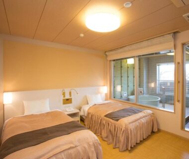 Western twin bedroom with glass balcony and wooden soaking tub at Itoen Hotel Kusatsu, Gunma
