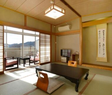 Tatami room with low table, shoji doors and balcony at Itoen Hotel New Sakura in Tochigi