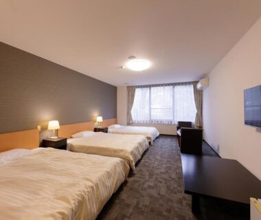 Spacious room with three beds, TV, low table and window at Itoen Hotel Shiobara in Tochigi