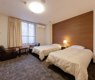 Twin beds with seating area and air conditioner at Itoen Hotel Shiobara, Tochigi