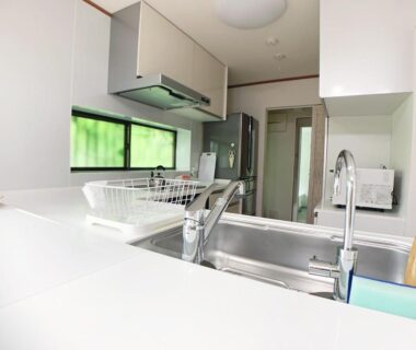 Bright modern kitchenette with stainless sink, range hood, refrigerator and countertop in Itsukaichi First Villa Hiroshima
