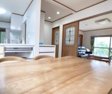 Wooden dining table, kitchenette and seating at Itsukaichi First Villa Hiroshima in Chūgoku, Japan