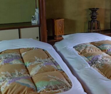 Two futons on tatami with shoji screens and wooden furnishings in an Itsumoya room, Hiroshima