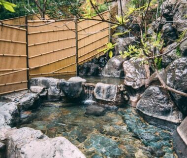 Rock-lined outdoor onsen bath at Iwaiyado Jyuan Nikko Kawaji in Tochigi, bamboo fence and natural stones