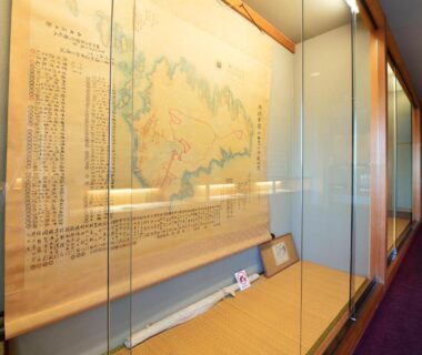 Glass display case with mounted map and small artifacts in Iwamotoro corridor, Kanagawa