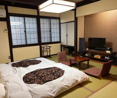 Traditional tatami room with futon bedding, shoji screens, low table and zabuton seating at Iwamura Sanso in Chūbu, Gifu
