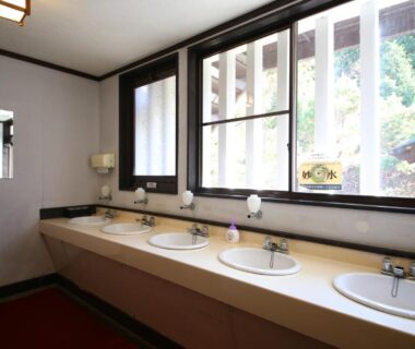 Row of washbasins beside wooden-latticed windows at Iwamura Sanso, Gifu