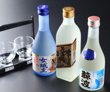 Three glass sake bottles with cups on a black tray at Iwamura Sanso in Chūbu, Gifu