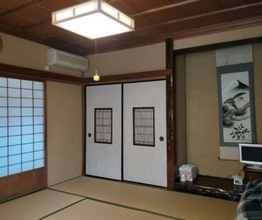 Traditional tatami room with shoji and fusuma doors, hanging scroll and small television