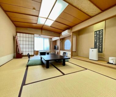 Traditional tatami room with low chabudai table, zabuton cushions, shoji sliding doors and hanging scroll at Izu Katsura Onsen Shizuoka