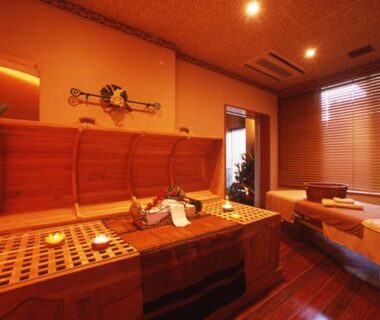 Warm-lit spa treatment room with wooden massage beds and furnishings at Izu-Nagaoka Hotel Tenbo Shizuoka