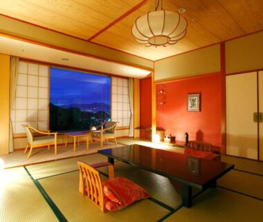 Traditional tatami room with low table, zabuton cushion, shoji screens and seating by window overlooking mountain view