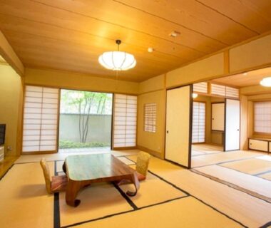 Spacious tatami room with low table, shoji screens and garden view at Izu Nagaoka Kinjokan, Shizuoka