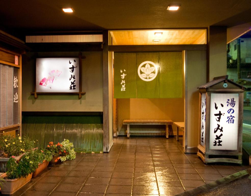 Lantern-lit entrance Izumi-so Gifu Warm lantern-lit ryokan entrance with noren curtain, wooden bench, potted plants and tiled entry at Izumi-so, Gifu, Chūbu