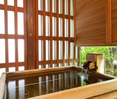 Wooden soaking tub with shoji screens and garden view at Izumiso ryokan in Nagano