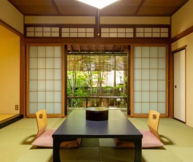 Traditional tatami room with low table, shoji screens and garden view at Izumiso in Nagano
