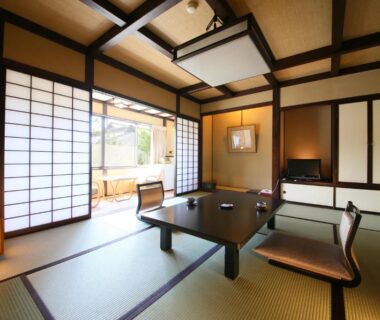 Traditional tatami room with shoji screens, low table and floor chairs overlooking garden at Izumiya Zenbe Nagano